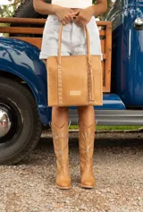 Bota texana de cuero vacuno color negro, con caña alta con recortes y apliques metálicos dorados. Taco de madera con folia de cuero.