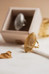 Anillo dorado con forma ovalada y diseño texturizado. Fabricado en acero quirúrgico con baño de oro 18k, hipoalergénico y resistente al agua.