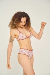 Conjunto de bikini con corpiño triangular con tirantes finos y bombacha clásica, ambos con estampado animal print multicolor y ribetes negros.