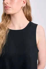 Top negro sin mangas de lino con botones decorativos en los laterales.