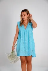 Vestido corto celeste con perforaciones, escote en V y mangas cortas con volados.