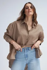 Camisa oversize de color marrón, de manga larga y cierre frontal con botones.