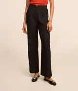 Pantalón de vestir negro de corte recto, con bolsillos laterales y cierre de cremallera lateral. Presenta detalles de hilo metalizado en la trama.