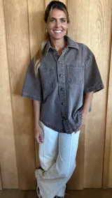 Sobrecamisa color gris oscuro de denim suave, con cuello clásico, cierre frontal con botones, mangas cortas y dos bolsillos de parche en el pecho.