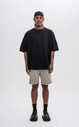Remera negra de manga corta con calce extra oversize y recorte en delantero y espalda, confeccionada en tejido jersey 24/1 americano.