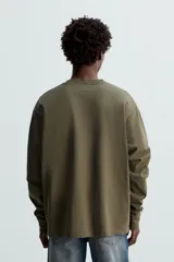 Camiseta verde militar de manga larga con cuello redondo y corte relaxed fit.