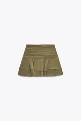 Falda pantalón corta color verde oliva, de tiro medio con detalle de pliegues en la cintura y volantes en el ruedo.