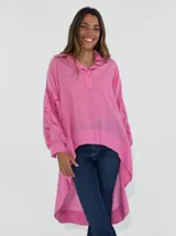 Blusa blanca de mangas largas con detalles de encaje en las mangas y cuello polo con cierre parcial.