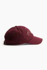 Gorra de béisbol color borgoña con bordado frontal de la frase "New York" y el número "1996" en blanco y rojo.