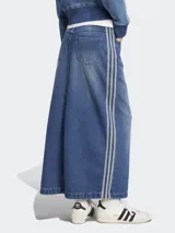 Falda larga de jean azul con corte recto y abertura frontal. Presenta tres tiras blancas verticales a los costados y logo de Adidas bordado en el frente.