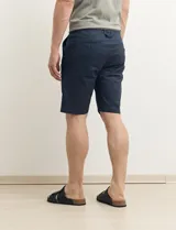 Bermuda de gabardina color verde con bolsillos laterales y traseros.