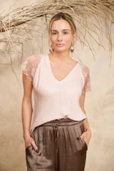 Blusa color rosa pálido de tela satinada con escote en V y mangas cortas de encaje floral.