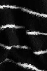 Remera de punto fino suave, color negro con rayas horizontales blancas, de corte entallado y mangas cortas.