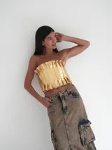 Top strapless de cuero color dorado con tablitas y elástico en la espalda.