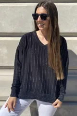 Sweater negro de tejido de punto con escote en V y rayas verticales plateadas.