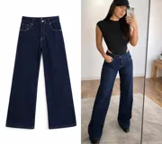 Jean de tiro medio y corte wide leg, confeccionado en denim azul oscuro con costuras en contraste. Presenta diseño de cinco bolsillos, cierre frontal con cremallera y botón metálico.