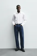Camisa celeste de corte regular, con cuello italiano, mangas largas con puños abotonados y cierre frontal con botones.