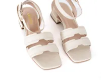 Sandalias de cuero color crema con taco cuadrado bajo y pulsera al tobillo con hebilla dorada.