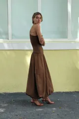 Vestido midi color marrón de escote asimétrico con manga sisa, con cuerpo superior de tejido de punto acanalado y falda globo con bolsillos laterales de plastrón con solapa. 