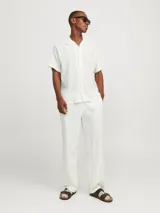 Camisa blanca de popelina con cuello resort, mangas cortas y cierre frontal con botones.