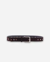 Cinto marrón de gamuza con tachas plateadas y hebilla metálica rectangular.