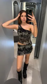 Conjunto de top asimétrico de un solo hombro y minifalda con estampado animal print en tonos grises y negros.