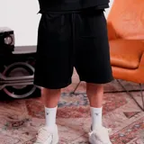 Bermuda de hombre color negro, de tela de algodón o similar, con cordón ajustable en la cintura y corte por encima de la rodilla.