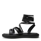 Sandalias negras con plataforma plana y tiras finas que se atan alrededor del tobillo.