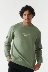 Buzo verde oliva de felpa con cuello redondo, puños y cintura acanalados. Estampado frontal con la frase "The Real Balance" en letras blancas y logo de la marca Mistral.