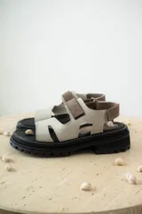 Sandalias con diseño moderno, color beige, con cierre trasero y suela gruesa para mayor comodidad.