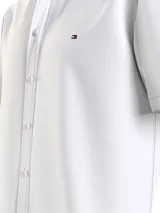 Camisa blanca de manga corta Tommy Hilfiger, corte regular, cuello abotonado y logo bordado en el pecho.