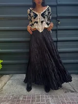Falda larga negra con textura arrugada y cintura elástica.