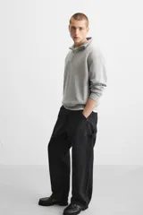 Pantalón de jean negro, corte relaxed fit, con bolsillos frontales y traseros tipo parche, tira multifunción y bolsillo tipo parche en las piernas. Tiene efecto lavado y cierre frontal con cremallera y botón.