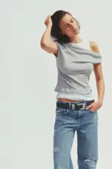 Camiseta blanca con musculosa gris superpuesta con escote asimétrico.