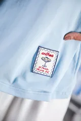 Remera azul marino de algodón con cuello redondo blanco y mangas cortas con bordado blanco.