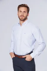 Camisa de rayas celeste, con manga larga, cuello con botones y bolsillos, diseño slim fit hasta talle XL.