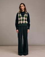 Chaleco de punto con patrón de rombos en tonos beige, verde y gris. Escote en V y ribete acanalado en el bajo. Sin mangas.