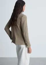 Blazer marrón con estampado de micro pata de gallo, cuello de solapa, cierre frontal con botón y bolsillos delanteros con solapa.