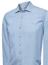 Camisa celeste de jean, de manga larga y corte clásico.