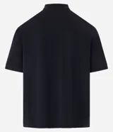 Remera boxy de mangas cortas, confeccionada en algodón, color negro, con cuello polo y lettering "93 MAD" y una cruz estampada en la parte delantera.