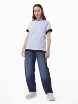 Remera celeste de algodón con cuello redondo y mangas cortas con puños negros. Estampado frontal con el logo de Tommy Hilfiger en color crema.