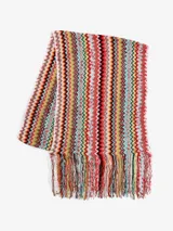 Bufanda larga de tejido suave con diseño de rayas en zigzag multicolor y flecos en los extremos.