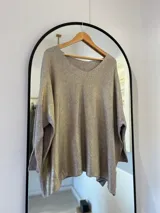 Sweater de punto color visón con escote en pico y detalle de brillo sublimado.