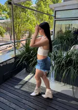 Short de jean azul con lavado claro, tiro alto y ruedo desflecado.