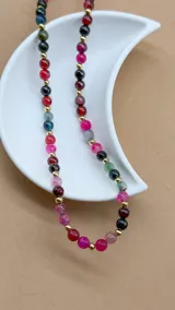 Gargantilla corta de cuentas de piedra natural ágata de colores rosa, celeste, negro y gris, con separadores de pequeñas esferas doradas.