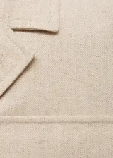 Chaqueta color beige con cuello de solapa, cierre frontal con botones, cuatro bolsillos frontales con solapa y manga larga.