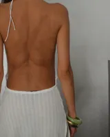 Minivestido blanco de tejido de punto calado, con escote halter y espalda descubierta.