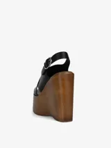 Sandalia negra con plataforma de madera y tira trasera ajustable con hebilla.