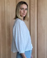 Camisa de mangas largas abullonadas con puños elásticos, cuello redondo y cierre frontal con botones.