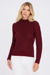 Sweater de punto calado color bordó, con cuello alto con volados y mangas largas.